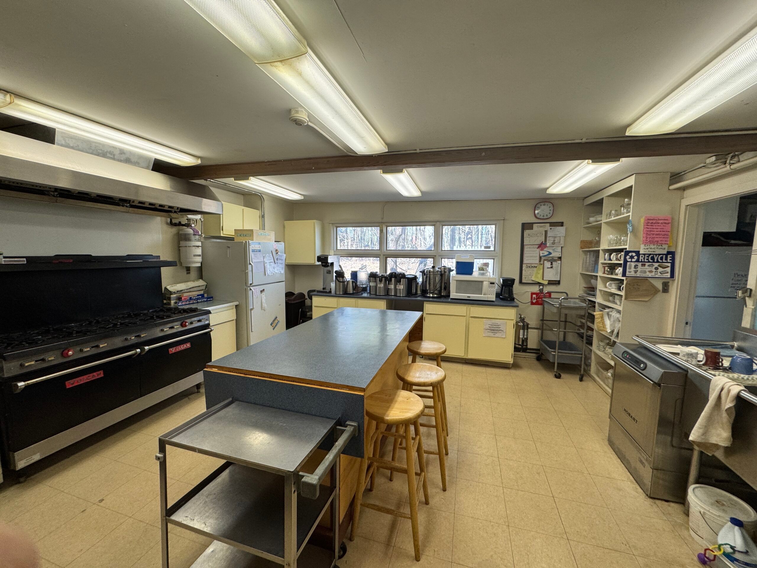 The commercial kitchen, with its gas range and stainless counters