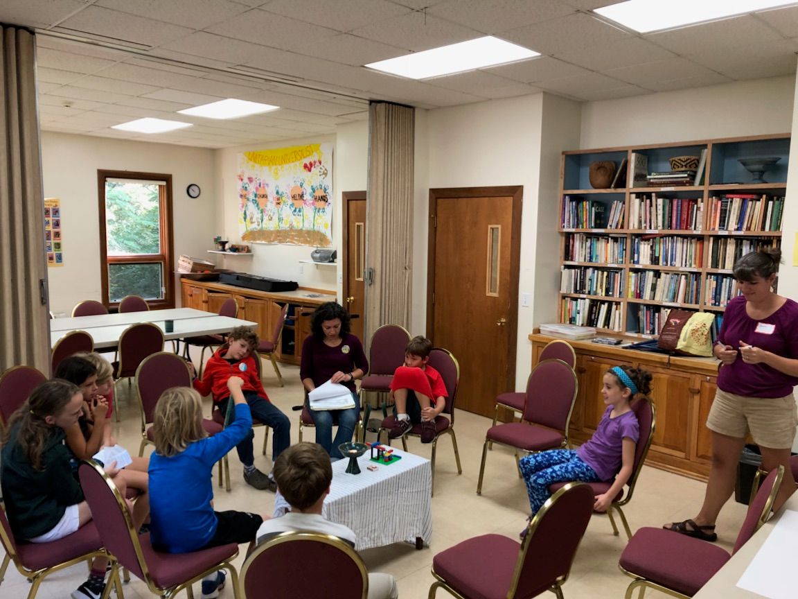 Children and adult volunteers gathered in a religious-education classroom