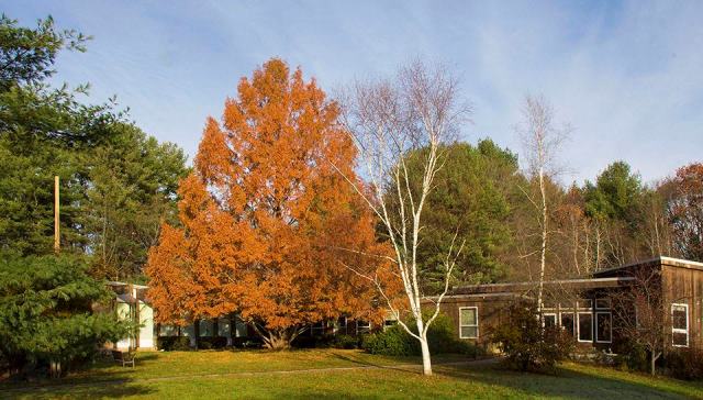The church exterior in fall, with paved walkways leading up to the entrances from the parking lot.